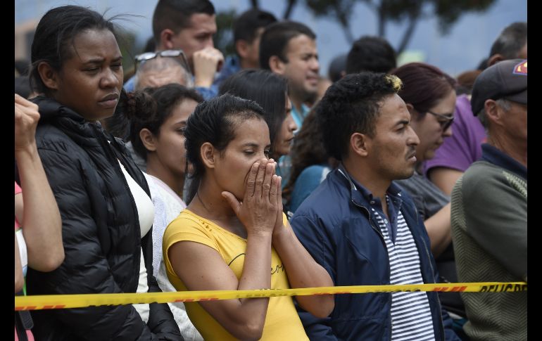 Personas aguardan afuera del lugar en espera de noticias.