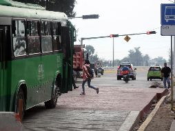 Los alumnos que buscaban cruzar el Periférico debían pasar sobre el terreno de la plancha en construcción, entre varillas, alambres y escombros. EL INFORMADOR / E. Barrera