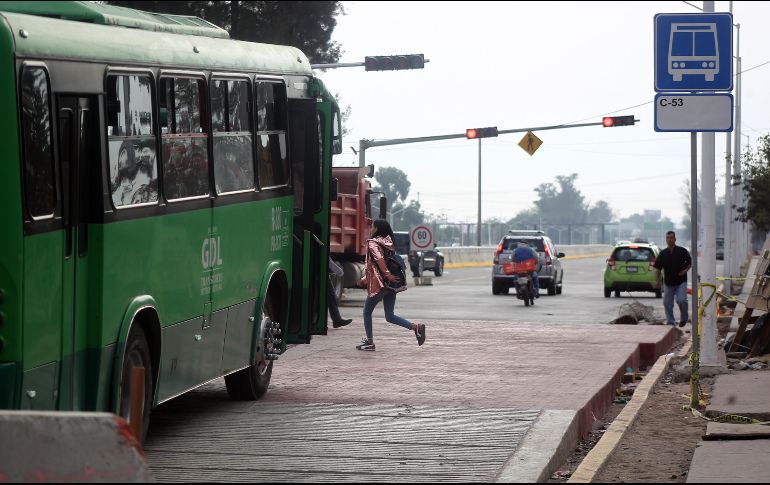 Los alumnos que buscaban cruzar el Periférico debían pasar sobre el terreno de la plancha en construcción, entre varillas, alambres y escombros. EL INFORMADOR / E. Barrera