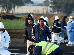 Un hombre reacciona mientras se encuentra en medio de expertos forenses que trabajan en la escena de la explosión de ayer en el estado de Hidalgo. AFP / A. Estrella