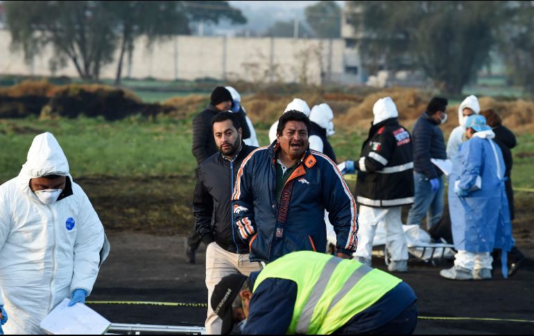 Un hombre reacciona mientras se encuentra en medio de expertos forenses que trabajan en la escena de la explosión de ayer en el estado de Hidalgo. AFP / A. Estrella