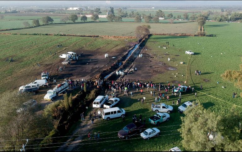 Rodeados por militares, marinos, policías federales y familiares de las víctimas, las autoridades recorren el lugar y marcan los indicios. AFP / E. Castro
