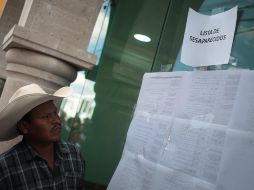 Familiares leen una lista actualizada de las víctimas y desaparecidos en la tragedia. EFE/J. Dan López