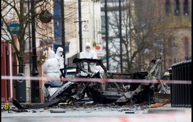 Oficiales inspeccionan el sitio donde el sábado explotó un coche bomba en ciudad de Londonderry, Irlanda del Norte. La policía atribuye el ataque a un grupo republicano disidente. AFP/P. Faith