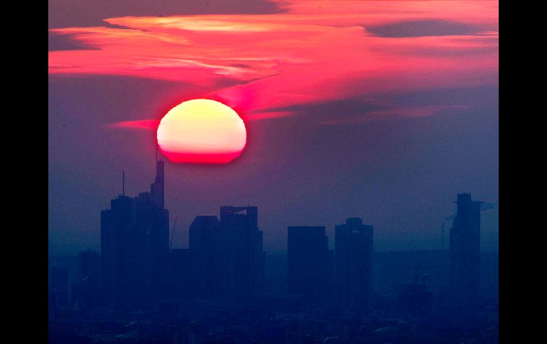 El Sol sale tras edificios en el distrito financiero de Fráncfort, Alemania. AP/M. Probst
