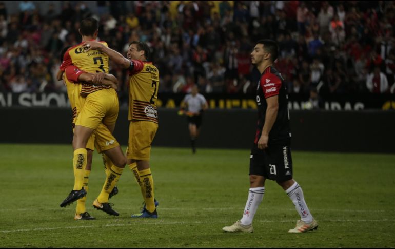 Leones Negros celebran el gol de la ventaja, ante el asombro del rojinegro Lorenzo Reyes. Los melenudos concretaron la sorpresa. EL INFORMADOR/F. Atilano