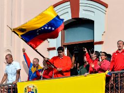 El presidente venezolano, Nicolás Maduro, sostiene una bandera nacional mientras habla con una multitud de simpatizantes, ayer, en Caracas. AFP/L. Robayo