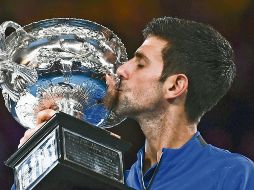 Novak Djokovic besa su trofeo tras ganar por séptima ocasión el Abierto de Australia. AFP