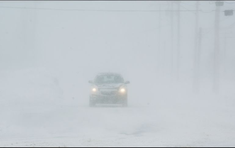Un auto transita por una avenida en St. Joseph, estado de Michigan, durante una nevada. AP/The Herald-Palladium/D. Campbell