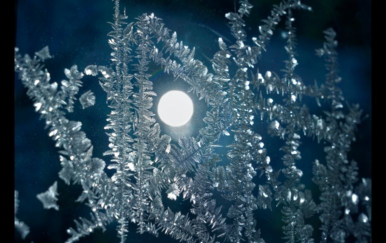 El Sol se ve a través del hielo en una ventana en Burnsville, Minnesota.