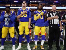 Jared Goff (16) y Todd Gurley (30) de los Rams, se ponen la mano en el corazón, pero el jugador a su derecha decide no hacerlo. AFP/J. Squire