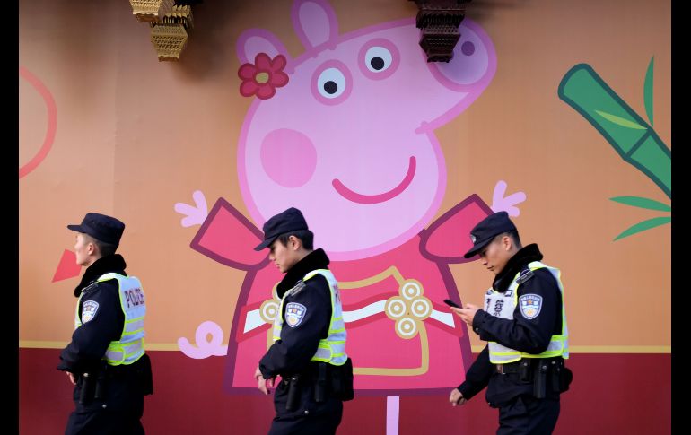 Policías pasan junto a una imagen de 