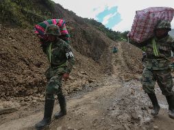 Militares bolivianos ayudan a pobladores a pasar este lunes por el deslizamiento en Puente Armas. EFE/M. Alipaz