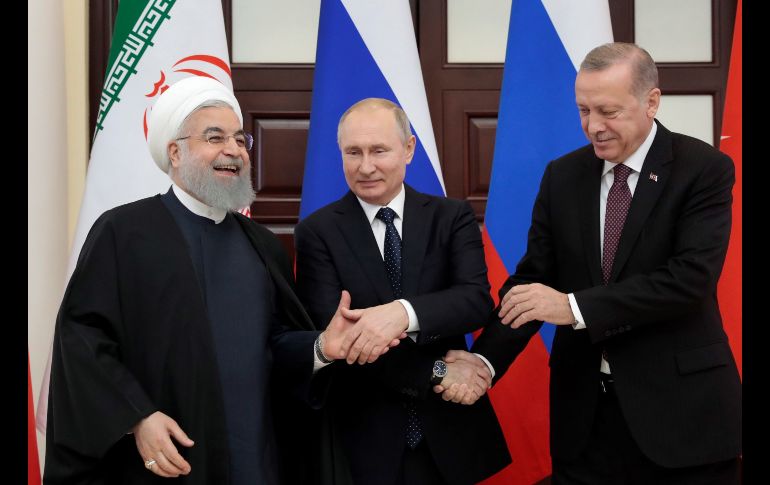 El presidente iraní, Hasán Rohuani (i a d); su homólogo ruso, Vladimir Putin, y el turco, Recep Tayyip Erdogan, se estrechan la mano durante su reuniónen el balneario de Sochi, Rusia, para abordar la situación en Siria tras la anunciada retirada de las tropas estadounidenses del país árabe. EFE/ S. Chirikov
