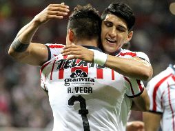 Alexis Vega y Alan Pulido celebran una de las anotaciones del delantero. AFP/U. Ruiz