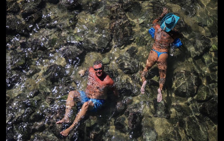 Turistas se divierten ante la baja del nivel del mar.