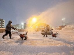 Habitantes quitan nieve de las entradas de sus viviendas esta mañana, en Nebraska. AP/Z. Long