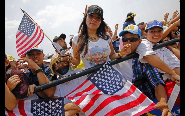 Una mujer sostiene una bandera estadounidense.