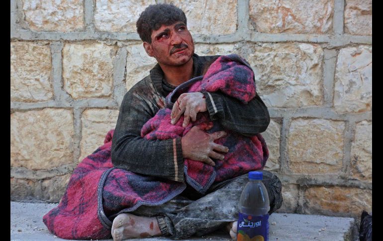 Un sirio llora mientras carga el cuerpo de su hija, quien murió tras un bombardeo en Khan Sheikhun, en la provincia de Idlib, bajo control de los rebeldes. AFP/A. Al-Dyab
