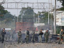 Agentes de la Guardia Nacional Bolivariana de Venezuela inspeccionan camiones incendiados durante el fin de semana durante enfrentamientos con manifestantes antigubernamentales. AP/F. Vergara