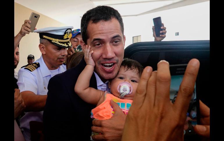 Juan Guaidó (c), reconocido como presidente interino de Venezuela por medio centenar de Gobiernos, posa para una foto con un bebé antes de dejar el hotel en Salinas, Ecuador. Guaidó llamó este domingo a manifestarse mañana en todo el país ante su regreso, luego de una gira que lo llevó a cinco países de Latinoamérica. AFP/R. Buendía
