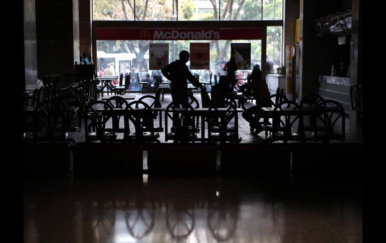 Un grupo de personas permanece en un local comercial a oscuras en Caracas.