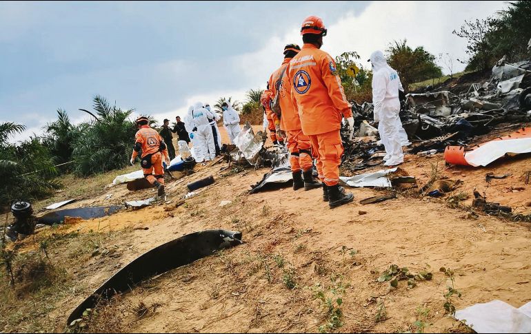 Socorristas y personal forense analiza los restos del aparato de fabricación estadounidense. AFP
