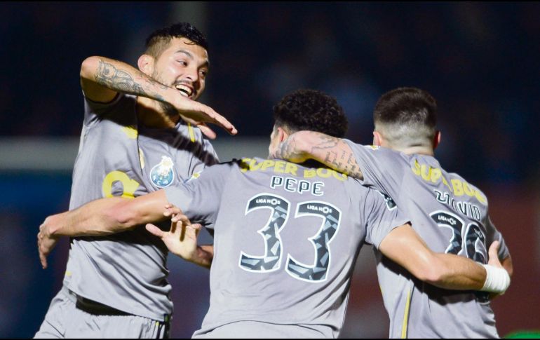 Jesús Corona (izquierda) se úne al festejo tras el primer gol de los Dragones. AFP