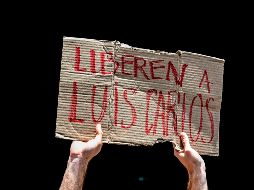 Un manifestante sostiene un cartel durante una movilización para exigir la liberación del periodista. AFP/R. Schemidt