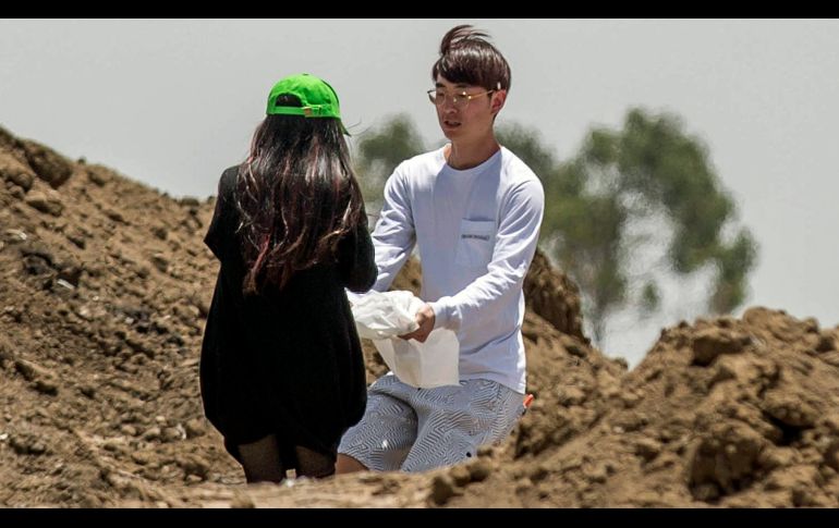 Unos recolectaron cenizas de entre los escombros.