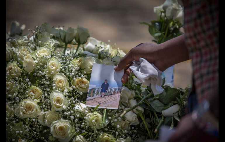 Una persona coloca una foto sobre flores.