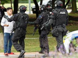 Policías hacen retroceder a personas de la escena de un tiroteo que resultó en múltiples muertes y lesiones, este viernes en Masjid Al Noor en Deans Avenue, en Christchurch (Nueva Zelanda). EFE/ M. Hunter