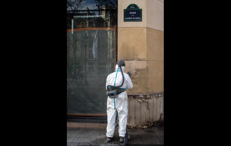 Un trabajador limpia un grafiti.