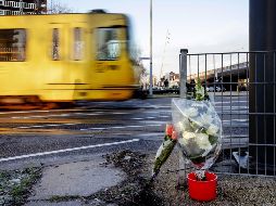 Un tranvía pasa junto a los ramos de flores depositados en el lugar del tiroteo. EFE/R. Van Lonkhuijsen