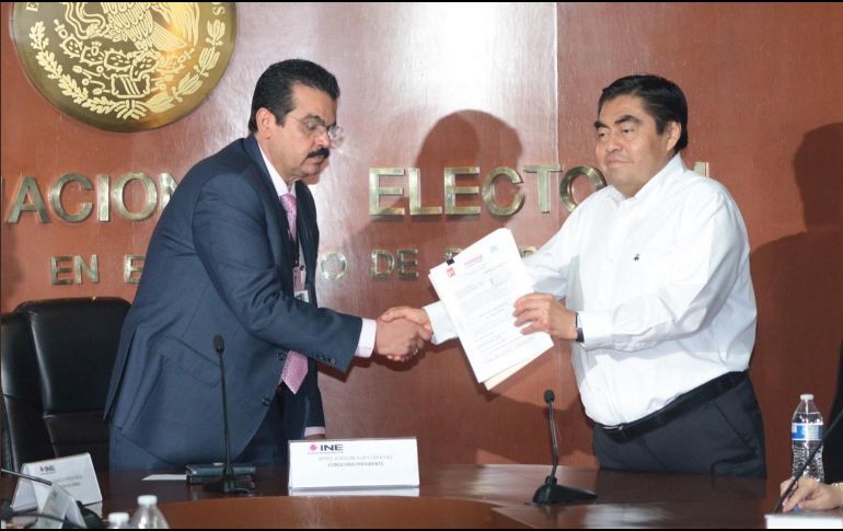 Miguel Barbosa entrega su solicitud a Joaquín Rubio Sánchez, vocal ejecutivo del INE Puebla. TWITTER/@MBarbosaMX