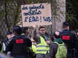 Un hombre muestra un cartel en el que se lee 