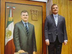 Tonatiuh Bravo, junto al óleo que se suma a la galería de la UdeG. EL INFORMADOR / G. Gallo