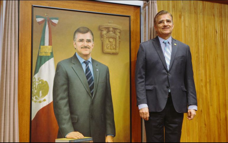 Tonatiuh Bravo, junto al óleo que se suma a la galería de la UdeG. EL INFORMADOR / G. Gallo