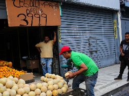 Un vendedor de frutas y verduras acomoda su mercancía en un mercado de Caracas. AFP/C. Hernández