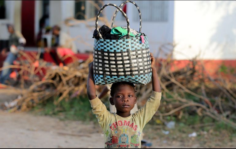 Una niña transporta ropa llegada en un barco en el río Buzi en Sofala, Mozambique. EFE/T. Petinga