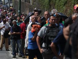 Personas hacen fila en Caracas  para tomar un autobús, debido a que el Metro no está funcionando por la falta de luz. EFE/ R. Peña