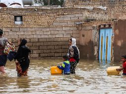 Una familia iraní camina por una calle inundada, en un pueblo cerca de la ciudad de Ahvaz. AFP/TASNIM NEWS