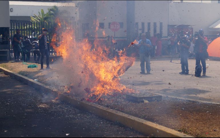 Manifestantes cuelgan de un árbol piñatas con cohetes pirotécnicos adentro. EFE/C. López