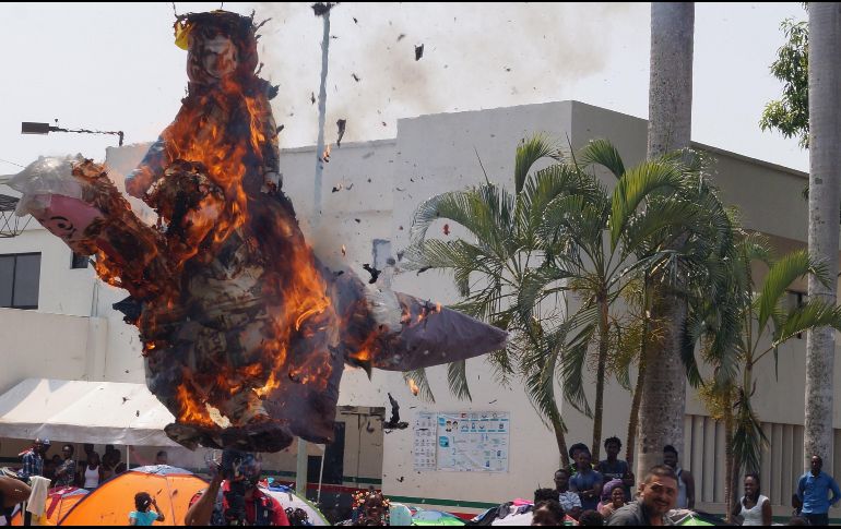 Manifestantes cuelgan de un árbol piñatas con cohetes pirotécnicos adentro. EFE/C. López