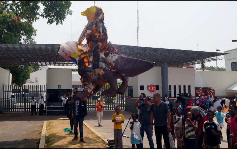 Manifestantes cuelgan de un árbol piñatas con cohetes pirotécnicos adentro. EFE/C. López
