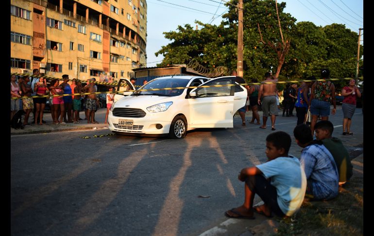 Vecinos observan la escena del crimen. AP/F. Teixeira
