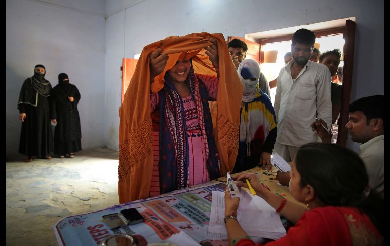 Una musulmana se levanta el velo para identificarse en una casilla en Shahpur, en la región de Uttar Pradesh. AP/A. Qadri