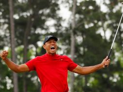 Tiger ruge, y un seguidor se llena los bolsillos de billeter verdes. AFP/K. Cox