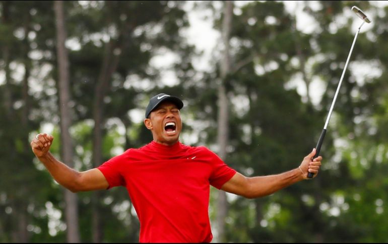 Tiger ruge, y un seguidor se llena los bolsillos de billeter verdes. AFP/K. Cox