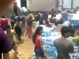 Las personas abrieron la caja del tráiler para sacar los paquetes y pasarlos a quienes los quisieran a pesar de la presencia de policías. ESPECIAL